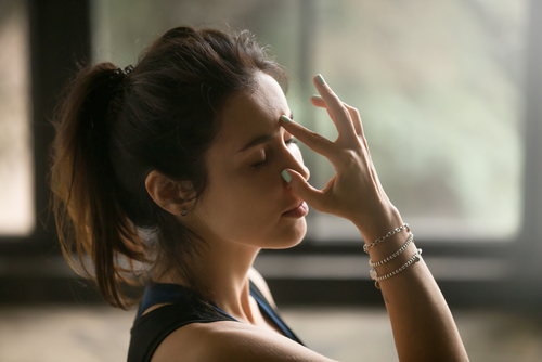 Young,Attractive,Woman,Practicing,Yoga,At,Home,,Making,Alternate,Nostril